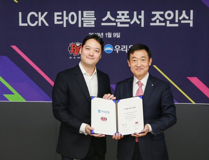 박준규 라이엇 게임즈 한국대표(왼쪽)과 정채봉 우리은행 부문장이 LCK 타이틀 스폰서 조인식에서 포즈를 취하고 있다.