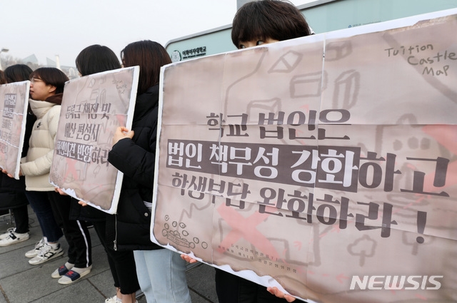 14일 오전 서울 서대문구 이화여자대학교 정문에서 열린 2019 등록금심의위원회 요구 공동행동 기자회견에서 학생들이 손피켓을 들고 있다. 사진=뉴시스