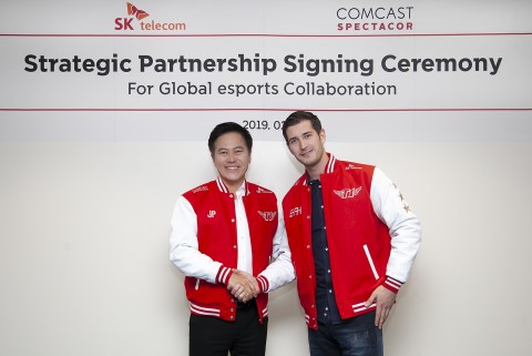 (왼쪽부터)SK텔레콤 박정호 사장과 컴캐스트 스펙타코어 터커 로버츠 e스포츠 총괄이 파트너십 체결 후 e스포츠 구단 T1 유니폼을 입고 기념촬영을 하고 있다