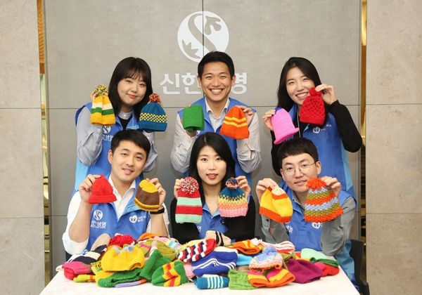 신한생명 직원들이 완성된 털모자를 들고 기념촬영을 하고 있다.