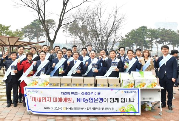 NH농협은행 박태선 부행장(앞줄 가운데)과 HR·업무지원부문 및 신탁부문 직원들이 20일 일산 킨텍스에서 미세먼지 피해예방 캠페인 직후 기념촬영을 하고 있다.