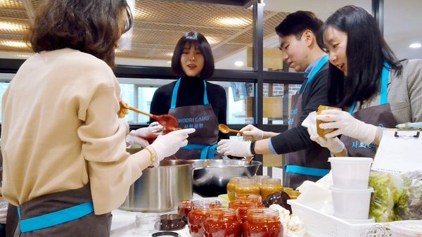 20일 종로노인종합복지관에서 진행된 '사랑의 장 담그기' 행사에서 우리카드 임직원들이 참여해 전통 장을 만들고 있다.