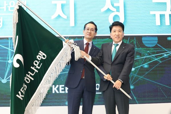 21일 을지로 KEB하나은행 신축 본점 1층 로비에서 진행된 KEB하나은행장 이취임식에서 지성규 신임 KEB하나은행장(왼쪽)과 함영주 전임 KEB하나은행장(오른쪽)이 은행 깃발을 함께 들고 힘차게 흔들고 있다.