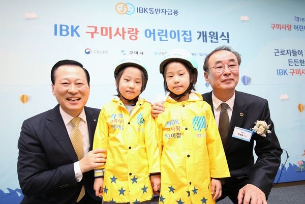 26일 구미에서 열린 ‘IBK 구미사랑 어린이집 개원식’에서 김도진 기업은행장(왼쪽 끝)과 장세용 구미시장(오른쪽 끝)이 박시은(오른쪽 두 번째), 박수현(왼쪽 두 번째) 어린이에게 선물을 전달하고 기념촬영을 하고 있는 모습. 사진=IBK기업은행