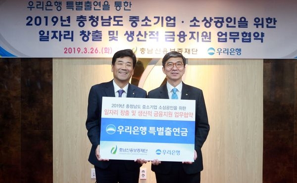 우리은행은 26일 충남 아산시 충남신용보증재단에서 ‘2019년 충청남도 중소기업·소상공인 일자리 창출 및 생산적 금융지원 업무협약’을 체결했다. 신명혁 우리은행 그룹장(오른쪽)이 유성준 충남신용보증재단 이사장과 기념촬영을 하고 있다.