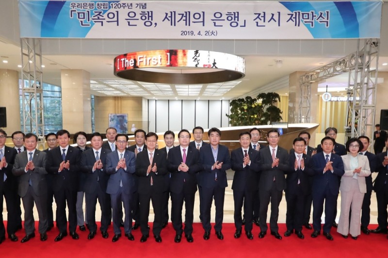 우리금융그룹은 2일 서울시 중구에 소재한 본점에서 120년 역사와 미래를 담은 기념 전시관 '민족의 은행, 세계의 은행'을 개관한 자리에서 손태승 우리금융그룹 회장(사진 첫번째줄 왼쪽 일곱째)이 박필준 우리은행 노조위원장(첫번째줄 왼쪽 여덟째), 우리금융 임원들과 기념촬영을 하고 있다. / 사진 제공=우리금융그룹
