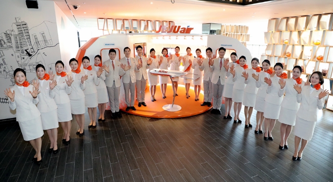 제주항공 신입승무원들이 제주항공이 운영하는 ‘홀리데이 인 익스프레스 서울 홍대’ 7층 로비에 설치된 브랜드 스토어 ‘오렌지 클라우드’에서 기념촬영을 하고 있다. / 사진 제공 = 제주항공