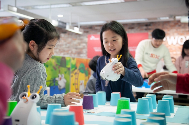 SK텔레콤은 경기도 일산 지점에서 초등학교 학생 20여명이 참가한 가운데 ‘신나는 코딩 교실’ 첫 수업이 열렸다고 14일 밝혔다. 또 전국 곳곳의 T월드 매장에서 시행 중인 ‘T스마트폰 교실’도 누적 수강생이 프로그램 시작 5개월만에 2,000명을 돌파했다. 수업에 참여한 어린이가 카드로 전후좌우 명령어를 입력해 알버트가 종이컵을 피해 목적지로 가는 미션을 수행하고 있는 모습. / 사진 제공 = SK텔레콤