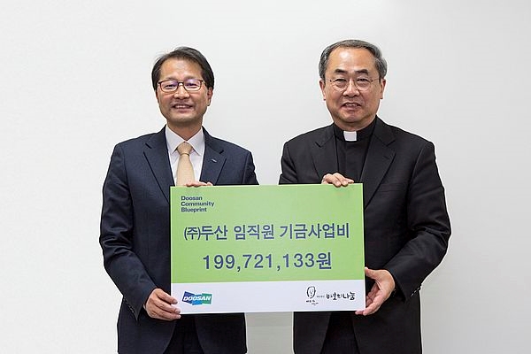15일 서울 명동성당에서 (주)두산 김윤건 전무(왼쪽)가 재단법인 바보의나눔 손희송 이사장에게 (주)두산 임직원이 모은 사회공헌 기부금 약 2억원을 전달한 뒤 기념촬영을 하고 있다. 사진 제공 = 두산