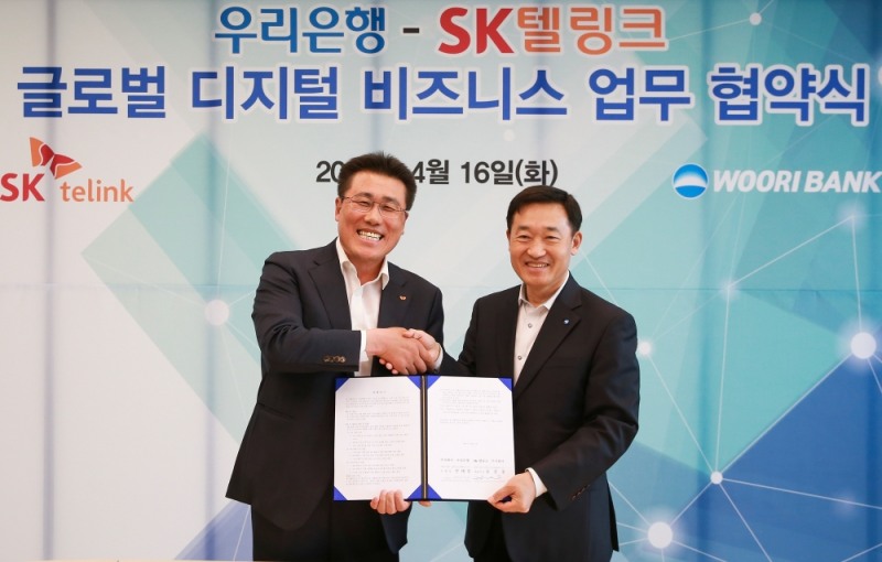 우리은행이 지난 16일 SK텔링크와 글로벌 디지털 비즈니스 협력을 위한 업무협약을 체결했다. 정채봉 우리은행 영업부문장(사진 오른쪽)이 김선중 SK텔링크 대표이사와 기념 촬영을 하고 있다. / 사진 제공 = 우리은행
