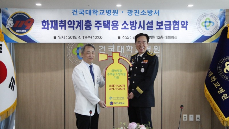 건국대병원은 17일 지역의 화재 취약 계층을 위해 광진소방서와 주택용 소방시설 보급 협약을 맺고 소화기와 감지기를 각 500개씩 지원하기로 했다. 건국대병원 황대용 병원장(왼쪽)이 이영우 광진구 소방서장에게 기증판넬을 전달하고 있는 모습.