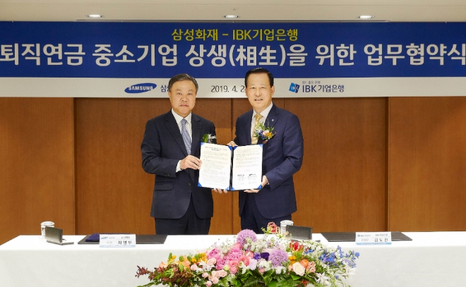 24일 을지로 기업은행 본점에서 김도진 기업은행장(오른쪽)과 최영무 삼성화재 사장(왼쪽)이 협약식을 마치고 기념촬영을 하고 있는 모습. / 사진 제공 = IBK기업은행