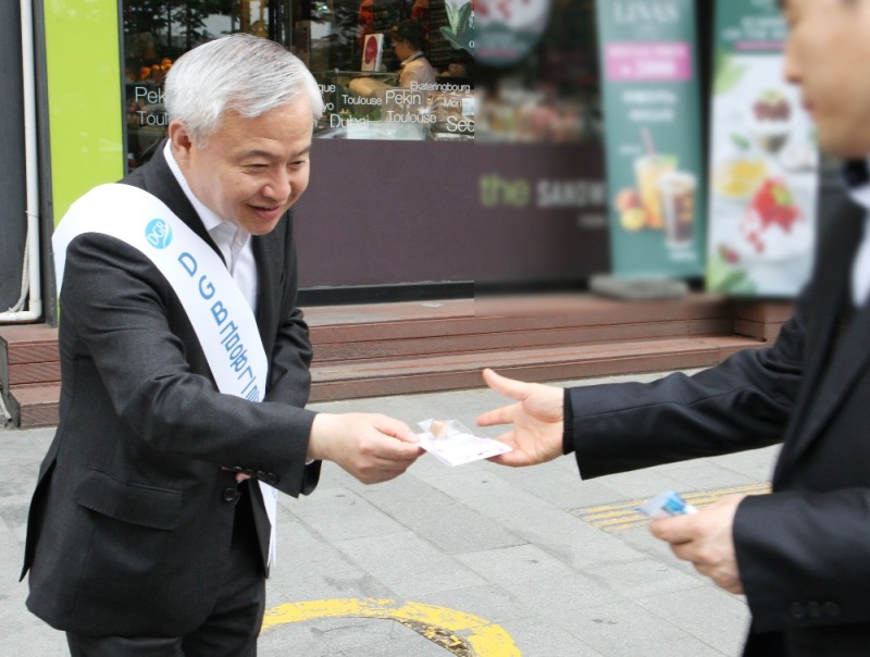하이투자증권 김경규 사장(왼쪽)이 25일 오전 서울 여의도역 인근 지역에서 임직원들과 함께 출근길 시민들에게 씨드볼을 전달하고 있다.