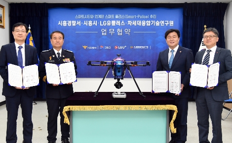 주요 관계자들이 U+스마트드론 옆에서 협약식을 체결하는 모습. 왼쪽부터 순서대로 정택동 차세대융합기술연구원장, 이재술 시흥경찰서장, 임병택 시흥시장, 조원석 LG유플러스 기업신사업그룹장 상무. / 사진 제공 = LG유플러스