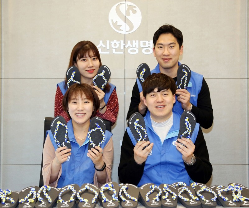 신한생명은 지난달 ‘폴짝 신발 만들기’ 캠페인을 진행하여 직원 봉사자들이 만든 800개의 폴짝 신발을 보건 위생키트와 함께 아프리카 탄자니아 어린이들에게 전했다. 직원 봉사자들이 폴짝 신발을 들고 기념촬영을 하고 있다.