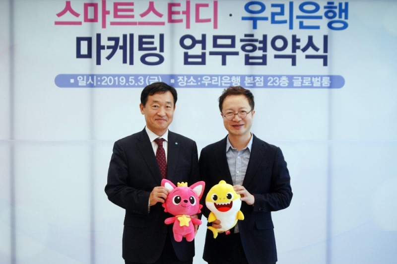 우리은행은 지난 3일 스마트스터디와 영유아 마케팅 강화를 위한 업무 협약을 체결했다. 사진은 정채봉(사진 왼쪽) 우리은행 영업부문장과 이승규 스마트스터디 CFO 가 핑크퐁과 아기상어 인형을 들고 기념사진 촬영을 하고 있는 모습. / 사진 제공 = 우리은행