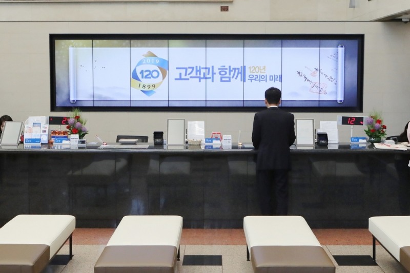 우리은행이 고객 맞춤형 서비스 제공을 위한 '디지털 사이니지'를 도입했다. 고객들이 디지털사이니지가 설치된 우리은행 본점영업부에서 업무를 처리하고 있다. / 사진 제공 = 우리은행
