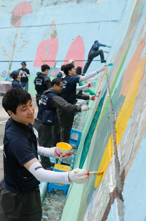 대림그룹 임직원들이 해오름빌 외부 벽화 작업을 하고 있다.