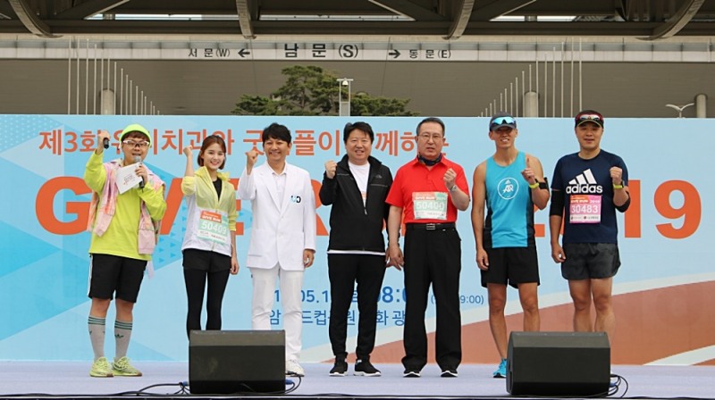 왼쪽부터 방송인 MC프라임, 탤런트 남보라, 진세식 유디치과 협회장, 김종명 ㈜유디 사장, 김천수 (사)굿피플인터내셔널 회장, 가수 션, 은총이 아빠 박지훈이 마라톤 출발 전 파이팅 하고 있는 모습