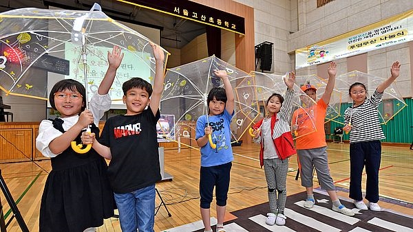 사진은 서울 고산초등학교 학생들이 현대모비스가 배포한 투명 우산을 들고 포즈를 취하고 있는 모습. / 사진 제공 = 현대모비스