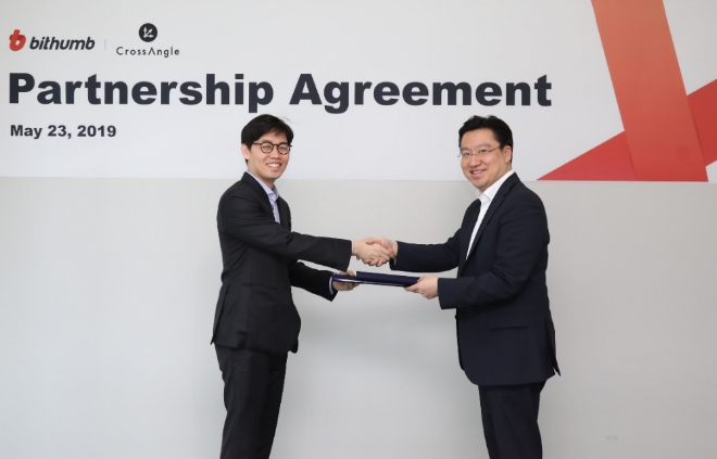 최재원 빗썸 대표(오른쪽)와 김준우 크로스앵글 대표가 지난 23일 서울 강남구 빗썸 본사에서 파트너십 협약을 맺고 악수를 하고 있다. /사진 제공 = 빗썸