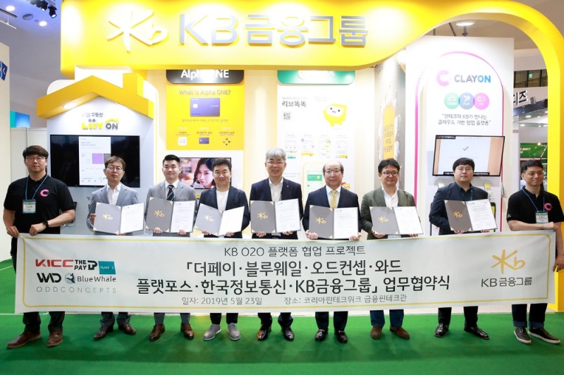 5월 23일 동대문디자인플라자에서 (왼쪽 2번째부터) 신영준 플랫포스 대표, 이원홍 블루웨일 대표, 용태순 와드 대표, 한동환 KB금융지주 디지털혁신총괄 전무 겸 KB국민은행 디지털금융그룹 대표, 임명수 한국정보통신 대표, 조병찬 더페이 대표, 안진명 오드컨셉 이사가 협약 체결을 기념하는 사진을 찍고 있다.