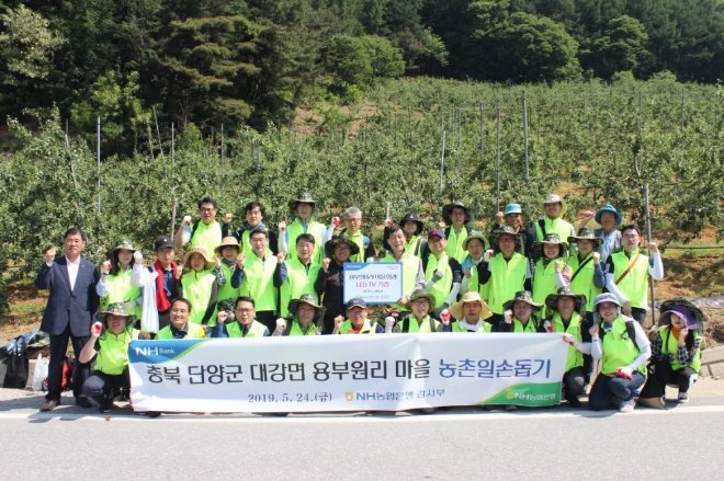 NH농협은행 이익중 상근감사위원(가운데줄 오른쪽에서 일곱번째)이 직원들과 일손돕기 후 사진촬영을 하고 있다. / 사진 제공 = NH농협은행