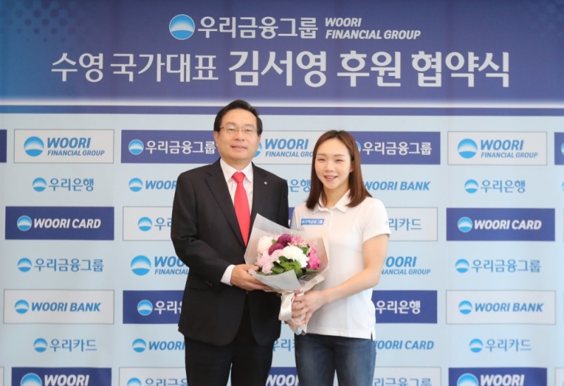우리금융그룹이 29일 서울시 중구 우리은행 본점 글로벌룸에서 ‘여자수영 국가대표 김서영 선수 후원 협약식’을 가졌다. 손태승 우리금융그룹 회장(사진 왼쪽)이 김서영 선수와 기념 촬영을 하고 있다. / 사진 제공 = 우리금융그룹