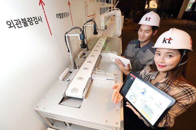 KT(회장 황창규)가 30일 서울 중구 더 플라자 호텔에서 기자간담회를 열고, 개방형 혁신(Open Innovation)을 통한 5G 스마트팩토리 추진전략을 발표했다. 사진은 모델들이 KT 5G 스마트팩토리 상품을 보여주는 미니 제조 공정라인을 소개하고 있는 모습으로 스마트패드를 통해 실시간으로 공장 내 상황을 확인할 수 있다. / 사진 제공 = KT