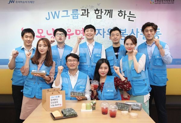 JW한마음봉사단원들이 단오 전통 음식을 만들고 기념촬영을 하고 있다./사진 제공 = JW홀딩스