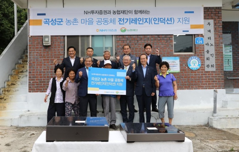 NH투자증권은 14일 전남 곡성군 고달면 두계리 마을회관에 전기레인지 110여대를 지원하는 행사를 진행하였다. (앞줄 왼쪽 세번째부터) 유근기 곡성군수, 김종현 두계리 마을이장, 정영채 NH투자증권 대표이사, 김남희 농협재단 사무총장 등이 마을주민들과 기념 촬영을 하고 있다.