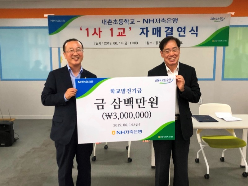 14일, 강원도 홍천군 내촌초등학교에서 진행된 「내촌초등학교-NH저축은행 ‘1사 1교’ 자매결연식」에서 NH저축은행 김건영 대표(왼쪽)가 내촌초등학교 한만식 교장(오른쪽)에게 학교발전기금을 전달하고 있다.