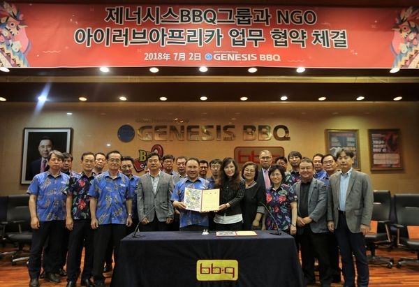 지난해 7월 윤홍근 제너시스BBQ 그룹 회장(맨 앞줄 왼쪽에서 세번째) 과 이창옥 아이러브아프리카 이사장(맨 앞줄 왼쪽에서 네번째) 이 업무협약을 체결하고 있다. / 사진 제공 = 제너시스BBQ