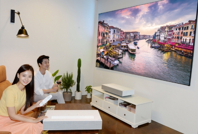 모델들이 스크린과 10cm 거리서 100인치 4K 초고화질 화면 구현이 가능한 'LG 시네빔 Laser 4K' 프로젝터(모델명:HU85LA)를 소개하고 있다. / 사진 제공 = LG전자