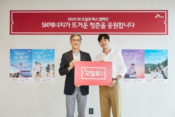 사진은 조경목 SK에너지 사장(왼쪽)과 배우 류준열씨(오른쪽)가 SK오일로패스를 들고 청춘들에게 응원의 메시지를 전하고 있는 모습. / 사진 제공 = SK에너지