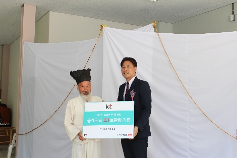 KT 지속가능경영담당 정명곤 상무(오른쪽)와 마을주민 은희장씨가 ICT 기반 공기구 무인 공유센터 ‘뚝딱뚝딱 공구소’ 개소식에서 공구소 기증서를 교환하고 있다. / 사진 제공 = KT