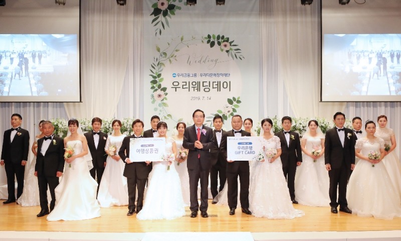 우리금융그룹 우리다문화장학재단은 지난 14일 서울 소공로 우리은행 본점 비전홀에서 다문화 부부를 위한 합동결혼식인 ‘제8회 우리웨딩데이’를 개최했다. 손태승(가운데) 우리다문화장학재단 이사장이 10쌍의 다문화 부부와 기념촬영을 하고 있다.
