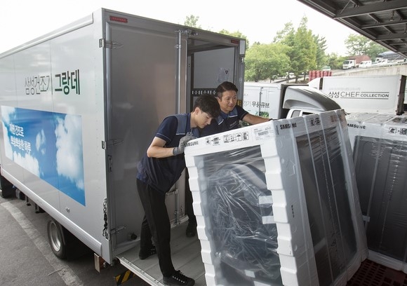 삼성전자 제품 배송·설치 담당자들이 경기도 고양시 일산서구에 위치한 삼성전자 서서울물류센터에서 삼성 건조기 그랑데를 배송하기 위해 차량에 싣고 있다.(사진 = 삼성전자 제공)