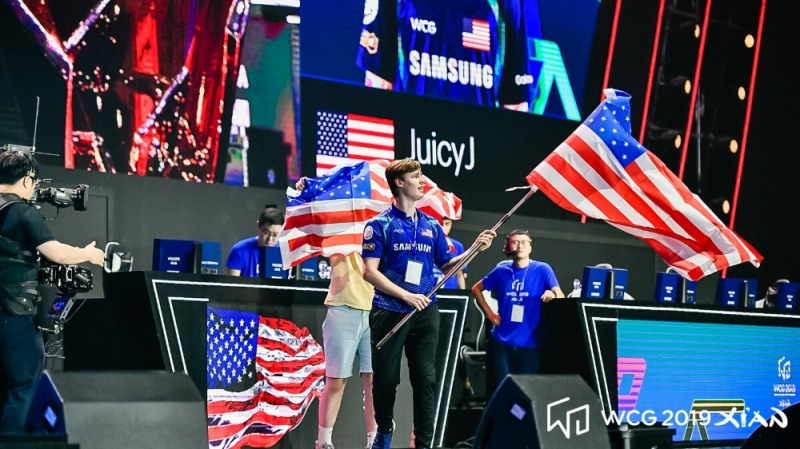 클래시 로얄 종목에서 우승한 미국 대표 'JuicyJ' 잭슨 왈이 국기를 흔들고 있다(사진=WCG 제공).