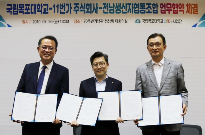 지난 26일 전라남도 목포대학교에서 진행된 ‘11번가-전남생협-목포대학교 전략적 업무제휴(MOU)’에서 11번가 김현진 커머스센터장(사진 중앙)과 전남생협 윤준웅 이사장(사진 좌측), 목포대학교 박민서 총장(사진 우측)이 포즈를 취하고 있다.