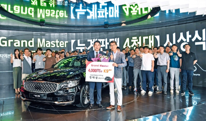 기아자동차㈜는 29일(월) BEAT360(강남구 압구정동 소재)에서 누계판매 4,000대를 달성한 전북 전주지점 정태삼 영업부장을 ‘그랜드 마스터(Grand Master)’로 임명하고, 상패와 포상차량 K9을 수여했다. 누계판매 4천대를 달성한 ‘그랜드 마스터’ 정태삼 영업부장(전북 전주지점)과 권혁호 기아차 국내영업본부장과 기념촬영을 하고 있다. / 사진 제공 = 기아자동차