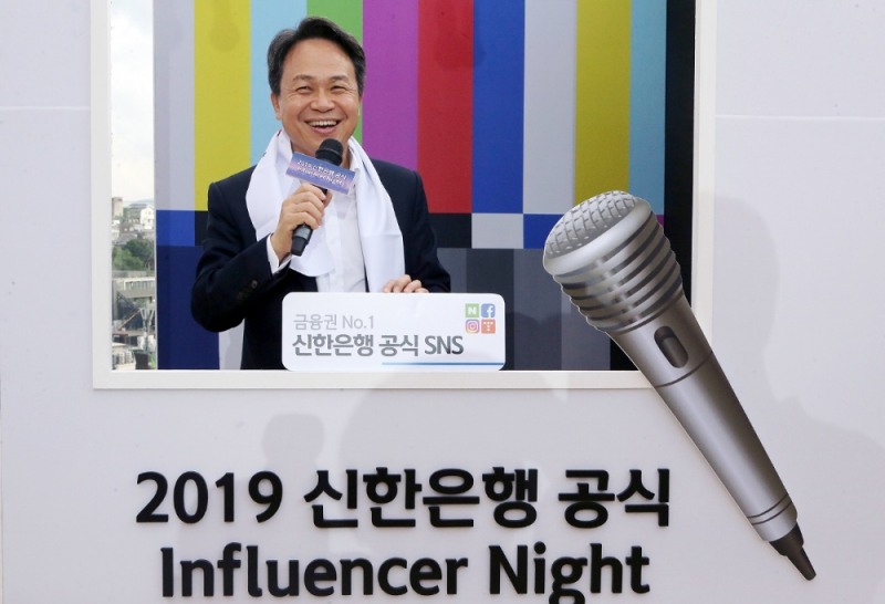 지난 29일 서울시 용산구 소월로 소재 복합문화공간 ‘앨리스 몽드’에서 진행된 신한은행 인플루언서 창단식에서 진옥동 은행장이 방송 컨셉 포토월에서 직원들에게 인사하는 모습. / 사진 제공 = 신한은행