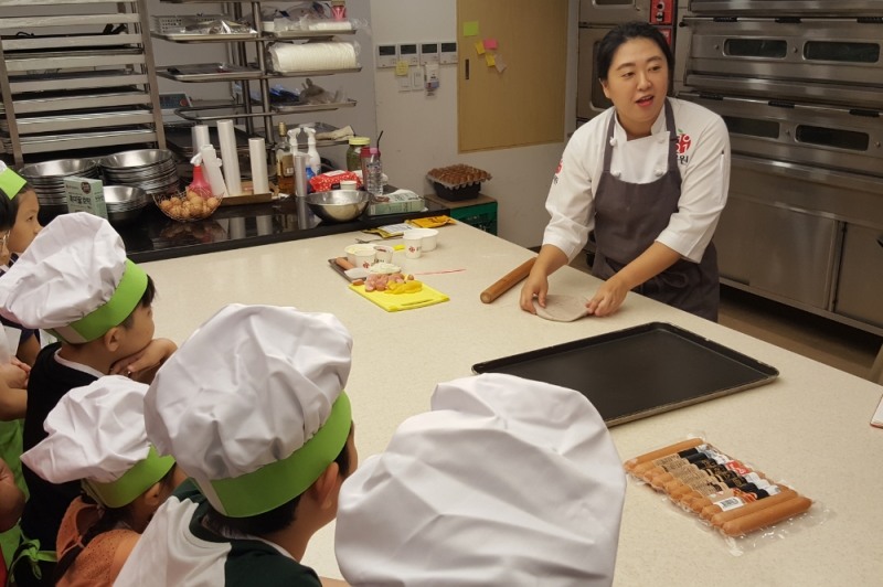 30일 종로 큐원 홈메이드플라자에서 열린 드림스타트와 함께 하는 쿠킹 클래스에서 삼양사 직원이 큐원 홈메이드믹스를 이용한 피자 만들기를 가르치고 있다. 