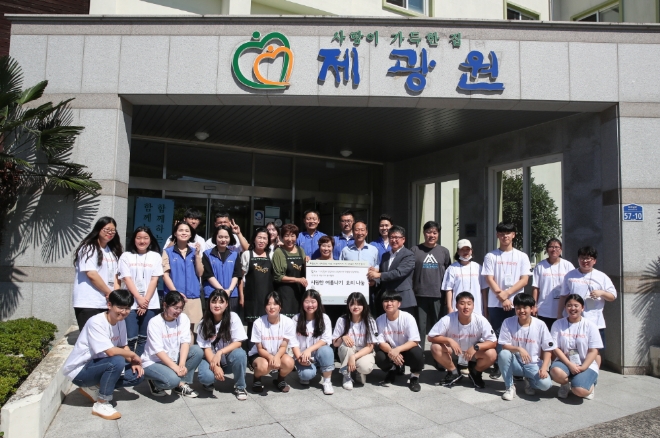 제주지역 나눔 봉사활동에 참여한 ‘맛있는 제주만들기’ 식당 주인들과 ‘드림메이커’ 학생, 호텔신라 임직원들이 물품 전달식 후 기념사진을 촬영하고 있다. / 사진 제공 = 호텔신라