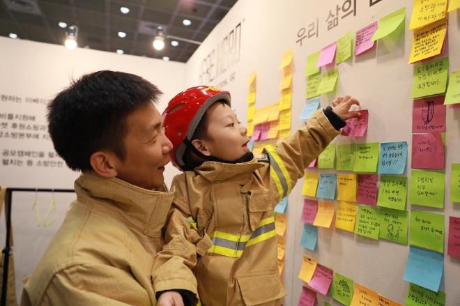 옥션을 통해 ‘코믹콘 서울 2019’ 행사에 초청 받은 소방관 가족이 소방관 응원 메세지 캠페인에 동참하고 있다. / 사진 제공 = 이베이코리아