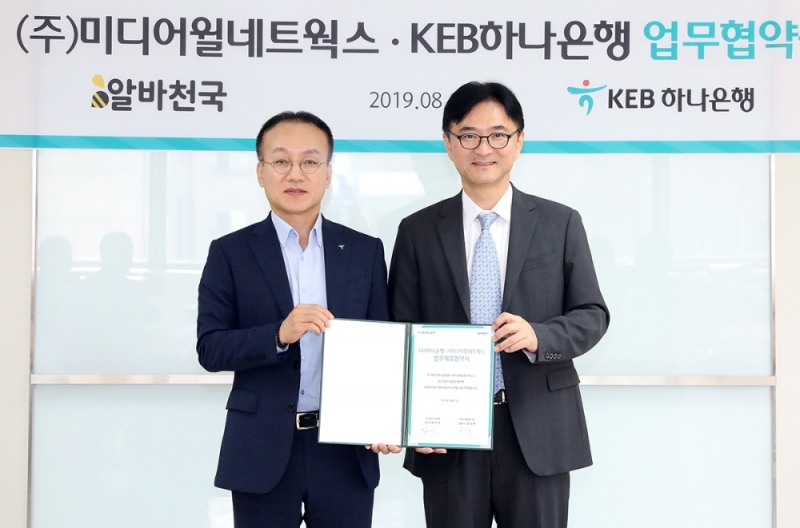 KEB하나은행은 (주)미디어윌네트웍스와 19일 서울 서초구에 위치한 KEB하나은행 서초영업본부에서 전략적 업무협약을 체결했다. 협약 체결 후 김기석 KEB하나은행 서초영업본부장(사진 왼쪽)과 공선욱 미디어윌네트웍스 대표(사진 오른쪽)이 기념촬영을 하고 있다.