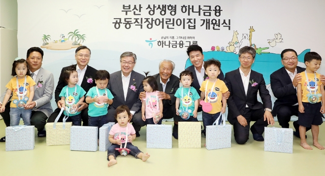 하나금융그룹은 28일 부산광역시 연제구 반송로에 위치한 KEB하나은행 연산동지점 2층에 영남지역 첫 번째 상생형 공동직장 어린이집 「부산 상생형 하나금융 공동직장 어린이집」을 개원했다.박승 하나금융그룹 사회공헌위원회 위원장(사진 왼쪽에서 네번째)과 함영주 하나금융그룹 부회장(사진 왼쪽에서 다섯번째)이 참석 내외빈 및 어린이들과 함께 기념 세레모니를 하고 있다. (사진 왼쪽부터) 김재우 워크재활의학과병원장, 심경우 근로복지공단 이사장, 이재갑 고용노동부 장관, 박승 하나금융그룹 사회공헌위원회 위원장, 함영주 하나금융그룹 부회장, 이성문 부산광역시 연제구청장, 이호성 KEB하나은행 영남영업그룹 총괄부행장