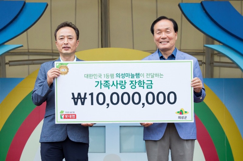 지난 6월 의성에서 진행된 10주년 의성마늘햄 가족캠프에서 이경석 롯데푸드 마케팅부문장(왼쪽)이 김주수 의성군수(오른쪽)에게 장학금을 전달하고 기념 사진을 찍고 있다.