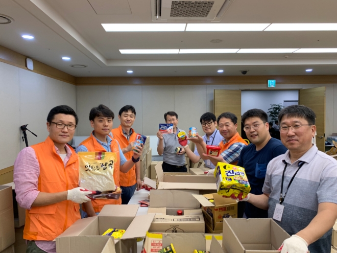 9월 4일(수), 이선석 한화첨단소재 대표(앞줄 가운데)와 임직원, 자원봉사자들이 송편을 직접 만들어 포장한 후 기념촬영을 하고 있다