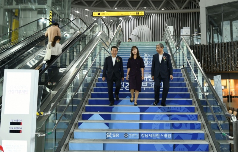 윤동섭 강남세브란스병원장(오른쪽 끝)과 권태명 SR 대표이사(왼쪽 끝)가 첫 번째 계단 이용객 최서희 씨(가운데)와 함께 건강기부계단을 이용하고 있다.